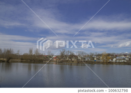 Pond with overhanging clouds against a blue sky Pond with overhanging clouds against a blue sky 100632798