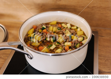 Different vegetables with forcemeat in white saucepan on kitchen. Mexican traditional food 100638930