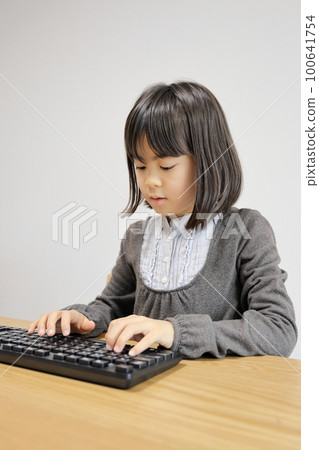 Female elementary school student hitting the keyboard (8 years old) Female elementary school student hitting the keyboard (8 years old) 100641754