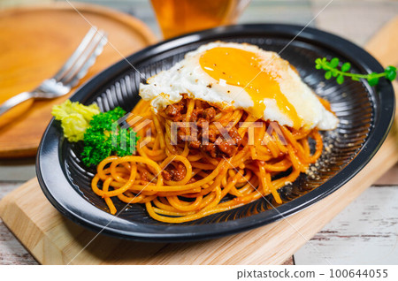 Fried egg topped with meat sauce spaghetti 100644055