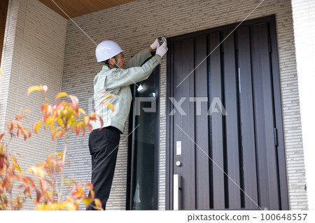 在入口處安裝安全攝像頭的男性工人 100648557
