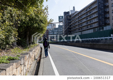 A man walking along the roadside strip at the end of the roadway A man walking along the roadside strip at the end of the roadway 100651317