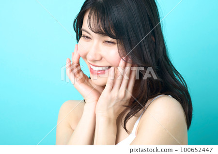 Beauty image of a sleeveless woman posing in front of a blue background Beauty image of a sleeveless woman posing in front of a blue background 100652447