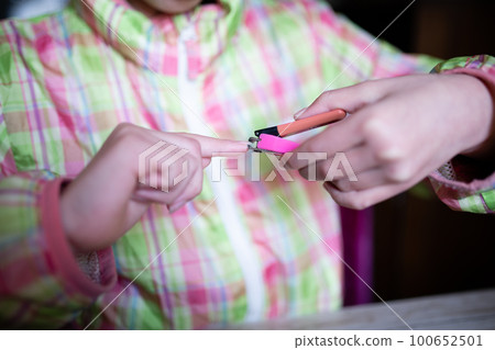 Child's hand cutting nails 100652501