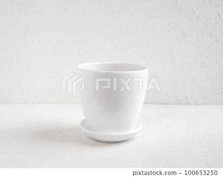 Empty new white flower pot stands on a white table. Copy space. 100653250