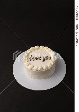 Small white cake on black background Small white cake on black background 100654679