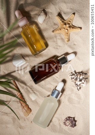 Three summer sunscreen essence on the sand backgroundwith shells ans seastar. Three summer sunscreen essence on the sand backgroundwith shells ans seastar. 100655451