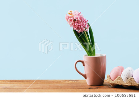 Easter eggs and hyacinth flower in mug. Wooden table with copy space Easter eggs and hyacinth flower in mug. Wooden table with copy space 100655681