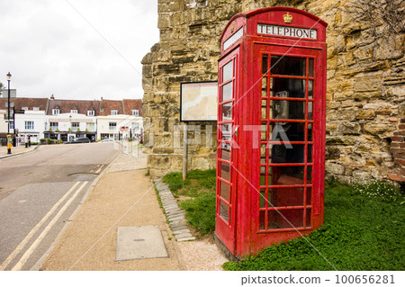 倫敦郊區一堵磚石牆旁的一個老式紅色電話亭 100656281