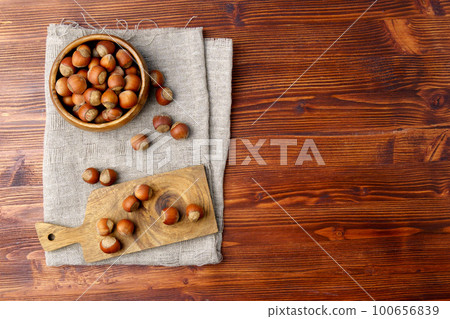 Hazelnuts on a wooden background, the top view copy space. 100656839