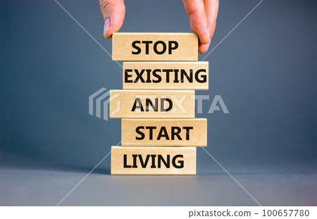 Stop existing start living symbol. Concept words Stop existing and start living on wooden blocks. Beautiful grey table grey background. Business Stop existing start living concept. Copy space. Stop existing start living symbol. Concept words Stop existing and start living on wooden blocks. Beautiful grey table grey background. Business Stop existing start living concept. Copy space. 100657780