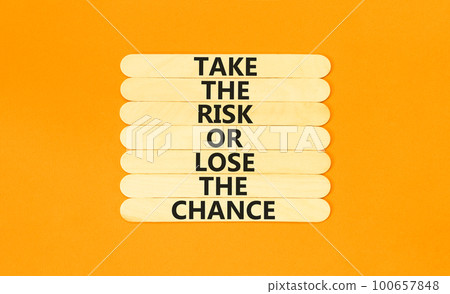 Risk or chance symbol. Concept words Take the risk or lose the chance on wooden stick. Beautiful orange table orange background. Copy space. Motivational business risk or chance concept. 100657848