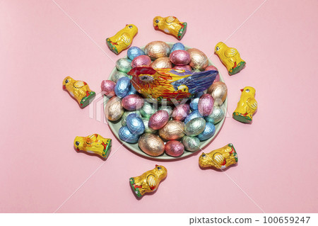 Top View Easter, Paschal kids gist. Chocolate hen, little chickens with festive colorful bright sweet eggs wrapped in foil on pink background. Confectionery, sweet-shop concept. Copy space,horizontal 100659247