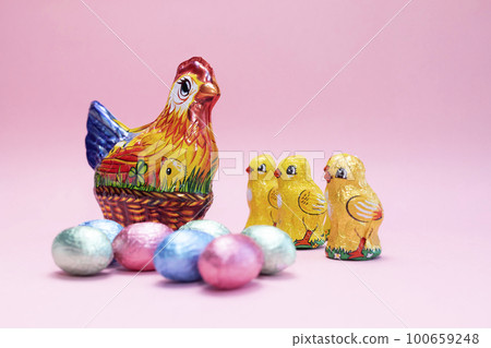 Easter, Paschal kids gist. Chocolate hen, little chickens with festive colorful bright sweet eggs wrapped in foil on pink background. Confectionery, sweet-shop concept. Copy space for text,horizontal 100659248