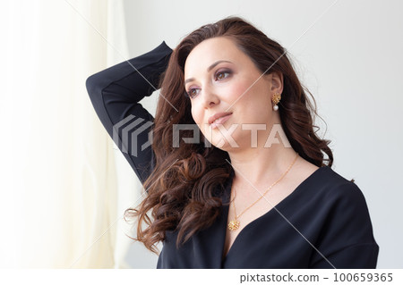 Elegant woman wearing luxury pendant and gold necklaces and earrings - jewellery and accessories concept 100659365