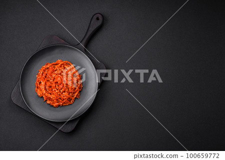 Dried squid chopped into slices and seasoned with sesame seeds and spices Dried squid chopped into slices and seasoned with sesame seeds and spices 100659772