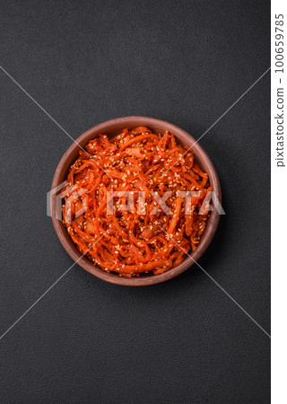Dried squid chopped into slices and seasoned with sesame seeds and spices 100659785