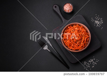 Dried squid chopped into slices and seasoned with sesame seeds and spices 100659787