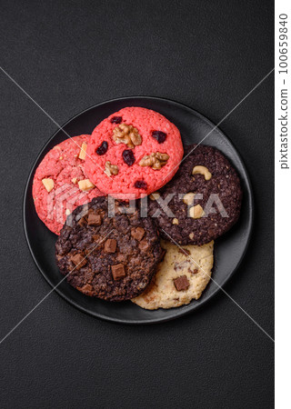 Delicious fresh crispy oatmeal cookies with chocolate and nuts Delicious fresh crispy oatmeal cookies with chocolate and nuts 100659840