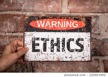 Ethics Concept. Warning sign with text in hand of woman. Red brick background Ethics Concept. Warning sign with text in hand of woman. Red brick background 100663999