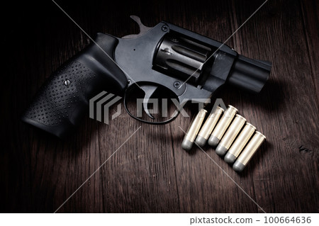 revolver handgun on wooden table revolver handgun on wooden table 100664636