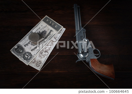 Old west revolver with bill and silver dollars Old west revolver with bill and silver dollars 100664645