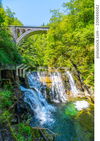 Stone railway viaduct over the Radovna river waterfall in the Vintgar Gorge. Triglav National Park, Slovenia. Stone railway viaduct over the Radovna river waterfall in the Vintgar Gorge. Triglav National Park, Slovenia. 100666082