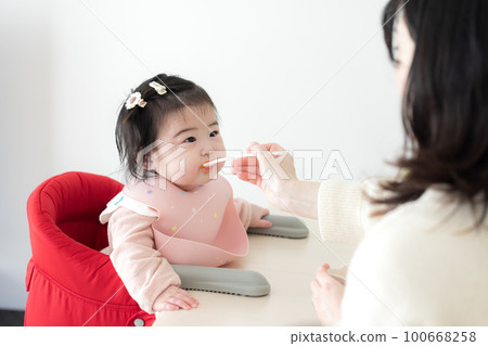 Baby eating baby food 100668258