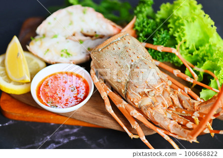 spiny lobster food on plate, fresh lobster or rock lobster seafood with herb and spices lemon coriander parsley lettuce salad, lobster for cooking food and seafood sauce 100668822