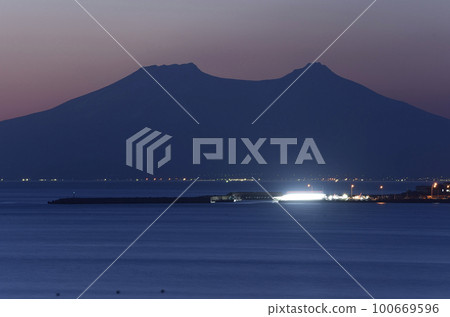早春從北海道八雲町落邊拍攝日出時分的駒岳和石倉漁港的景色 100669596