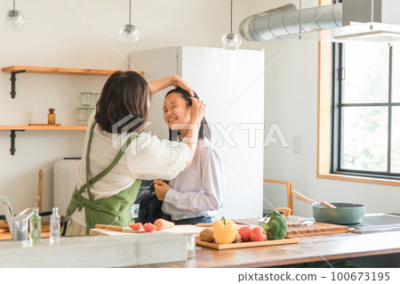 Mom and daughter getting ready in the morning in the kitchen at home (elementary school, junior high school, high school girls) 100673195