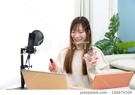 Video shoot, woman delivering with tablet and microphone, video shooter, broadcaster, YouTuber 100674109