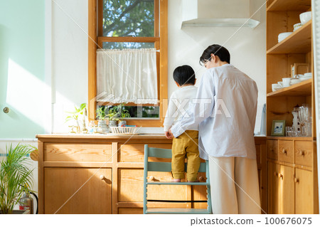 A 3-year-old boy playing with his mother in the kitchen A 3-year-old boy playing with his mother in the kitchen 100676075
