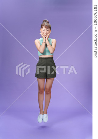 Full size photo of pretty nice cute woman jump up air smile hold hands face cheeks Full size photo of pretty nice cute woman jump up air smile hold hands face cheeks 100676183