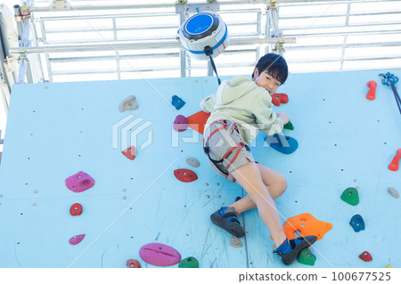 Child enjoying top rope climbing 100677525