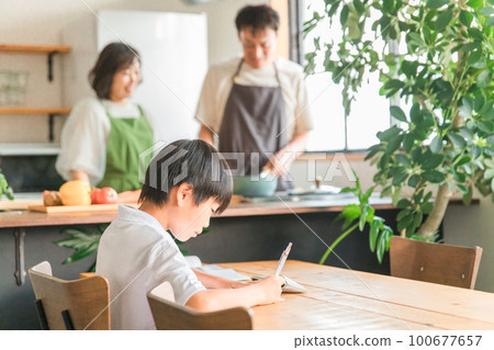 一個小學低年級的男生,在家裡的餐廳、客廳、客廳做功課和學習 一個小學低年級的男生,在家裡的餐廳、客廳、客廳做功課和學習 100677657