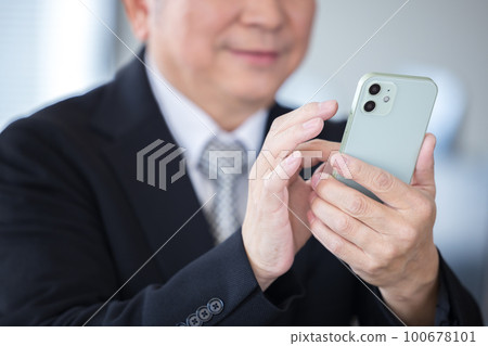 Business hand of a senior man looking at a smartphone 100678101
