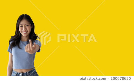 Women beckoning or inviting them to pay attention, Suggest to click or apply with me, Giving assistance and acceptance, Calling with one finger, Come and get me, Woman on yellow background. 100678630