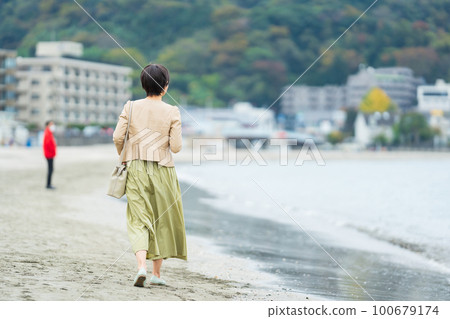 走在沙灘上的中年婦女的背影 100679174