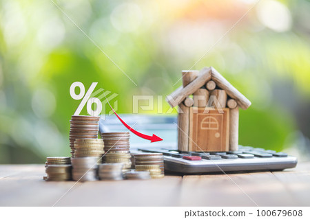 Houses and coins laying on a wooden table as a ladder with a white illustration showing a decrease in interest rates. plan savings money of coins to buy house ideas for property ladder, mortgage. 100679608