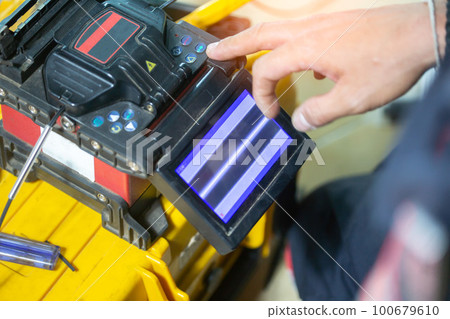 Banner template Technician Fiberoptic Fusion Splicing. Worker connecting for Cable Internet signal and Wire connection with Fiber Optic Fusion Splicing machine,fiber optic cable splice machine in work 100679610