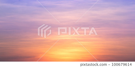Real amazing panoramic sunrise or sunset sky with gentle colorful clouds. Long panorama, crop it. Evening sky scene with golden light from the setting sun 100679614