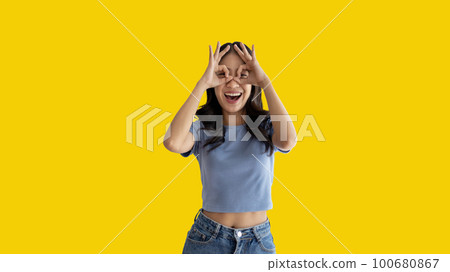 Young woman covering her face and eyes with her hands isolated, Cover your eyes with your hands for fear or prying eyes, Sneak peek, Yellow background. Young woman covering her face and eyes with her hands isolated, Cover your eyes with your hands for fear or prying eyes, Sneak peek, Yellow background. 100680867