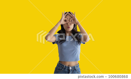 Young woman covering her face and eyes with her hands isolated, Cover your eyes with your hands for fear or prying eyes, Sneak peek, Yellow background. Young woman covering her face and eyes with her hands isolated, Cover your eyes with your hands for fear or prying eyes, Sneak peek, Yellow background. 100680868