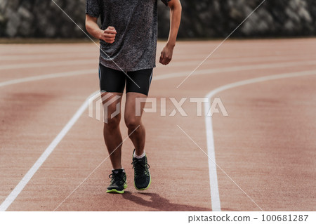Male runner running straight on athletics track Male runner running straight on athletics track 100681287