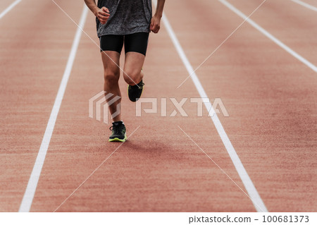 Male runner running straight on athletics track Male runner running straight on athletics track 100681373
