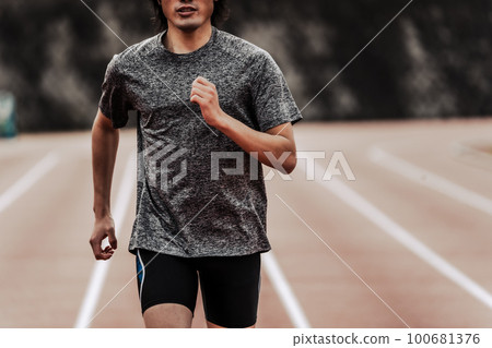 Male runner running straight on athletics track Male runner running straight on athletics track 100681376
