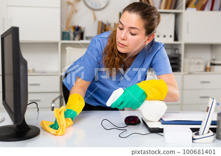 Young friendly cleaning woman in work uniform Young friendly cleaning woman in work uniform 100681401