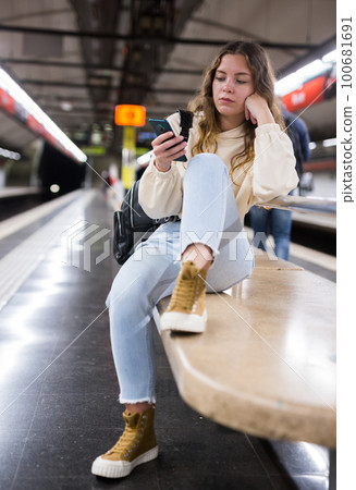 Young attractive girl in jeans waiting for subway train on a platform Young attractive girl in jeans waiting for subway train on a platform 100681691