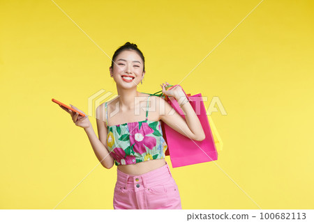 young woman holding shopping bags and smart phone young woman holding shopping bags and smart phone 100682113